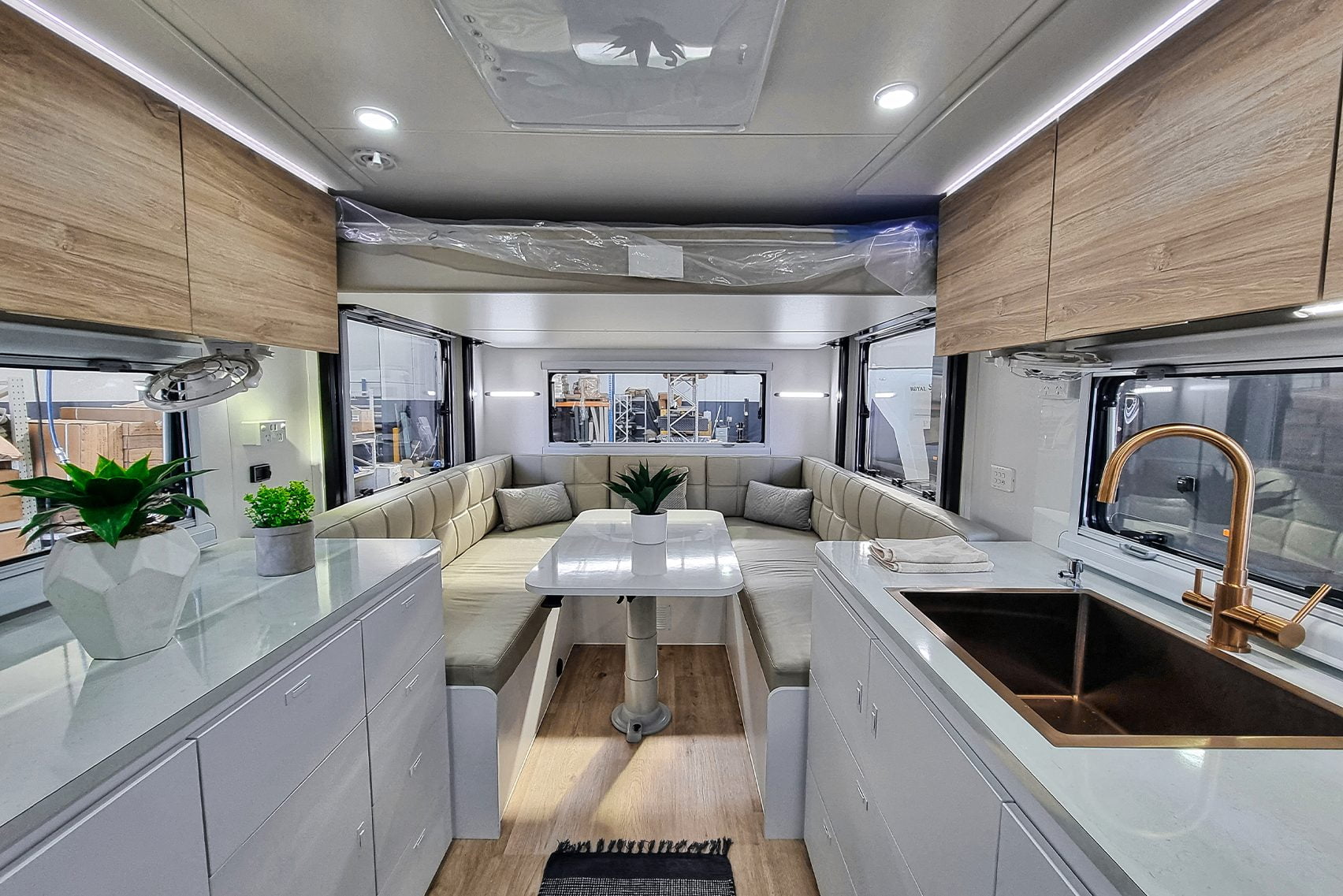 Elegant Royal Flair Aussiemate caravan with inviting kitchen seating, luminous interior, and integrated storage compartments