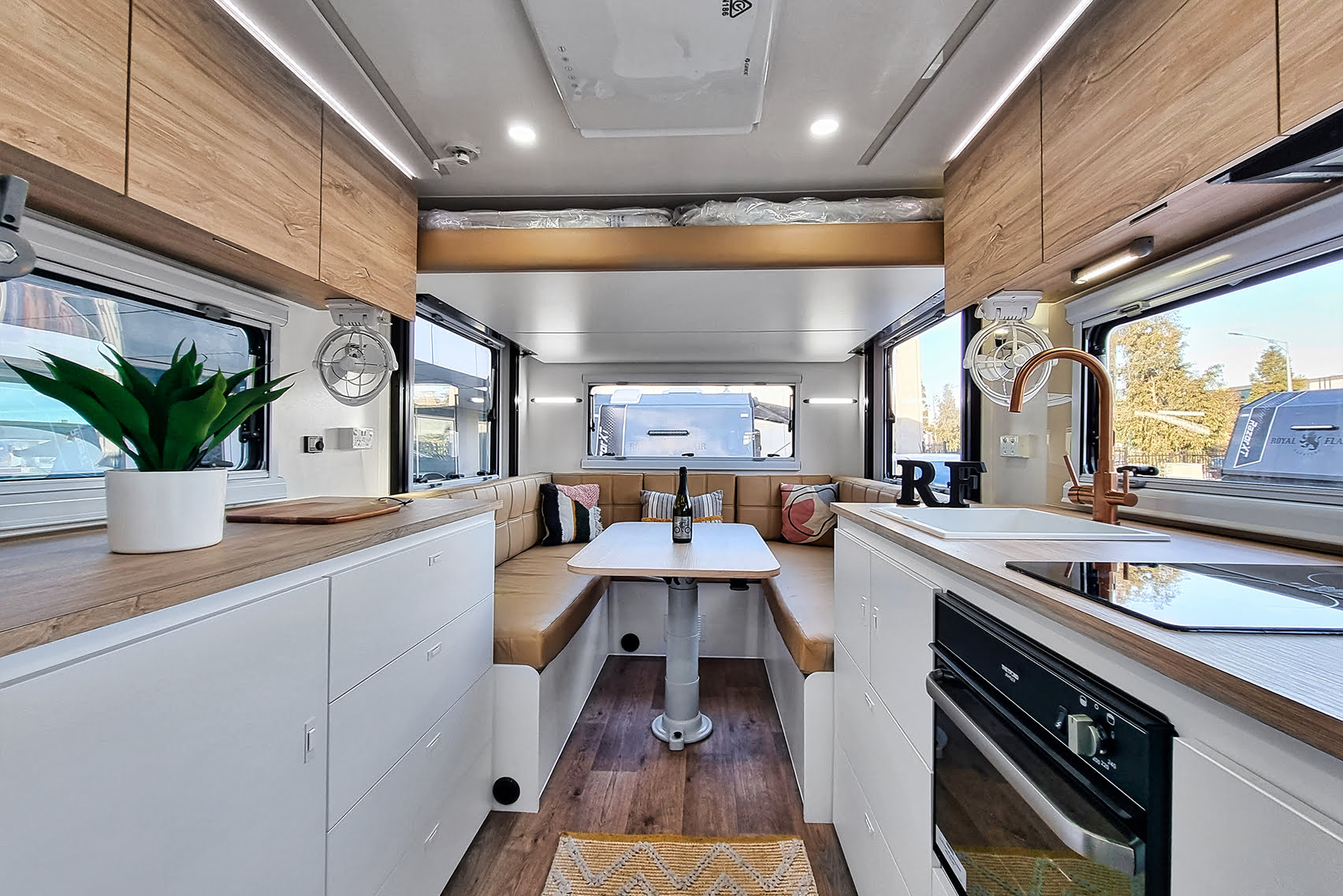 Regal Royal Flair Aussiemate caravan showcasing a homely kitchen, radiant light from windows, and organized storage facilities